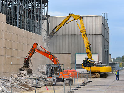 Baufahrzeuge bei Abrissarbeiten an einer Wand.