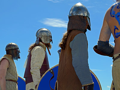 Eine Gruppe von Kriegern in historischen Rüstungen und Helmen steht im Freien.