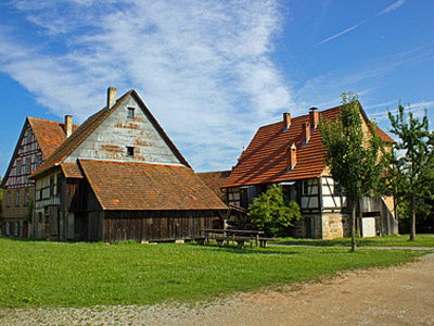 Zwei traditionelle deutsche Fachwerkhäuser vor einem blauen Himmel.