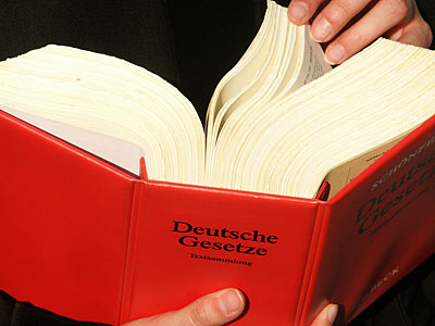 Ein offenes Buch mit rotem Einband, beschriftet mit "Deutsche Gesetze".