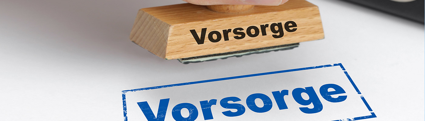 Ein Handstempel mit der Aufschrift "Vorsorge", der einen blauen Abdruck auf ein Blatt Papier hinterlässt.