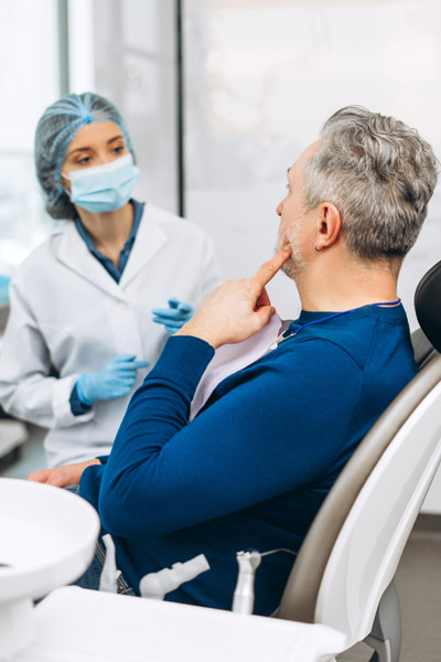 Ein Zahnarztgespräch zwischen einem Mann und einer Zahnärztin.