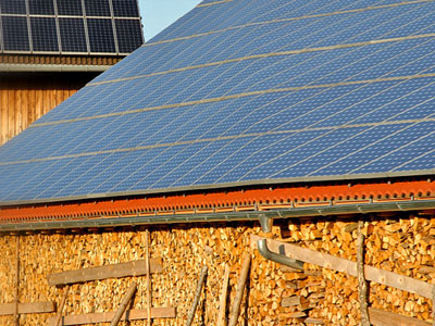 Ein Dach mit Solarzellen und einer Wand aus gestapeltem Holz.