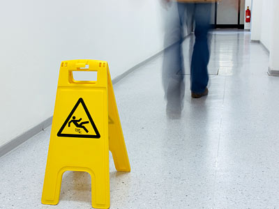 Achtung! Rutschgefahr. Gelbes Warnschild im Flur.