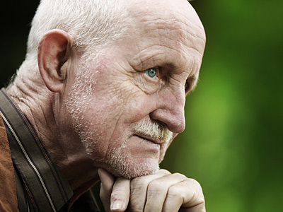 Ein älterer Mann denkt nach, mit einem nachdenklichen Gesichtsausdruck.