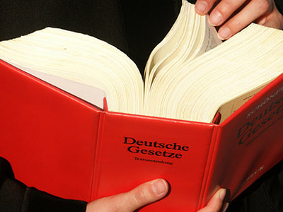 Ein offenes Buch mit rotem Einband, beschriftet mit "Deutsche Gesetze".