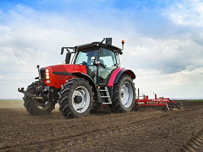 Ein roter Traktor fährt über ein Feld.