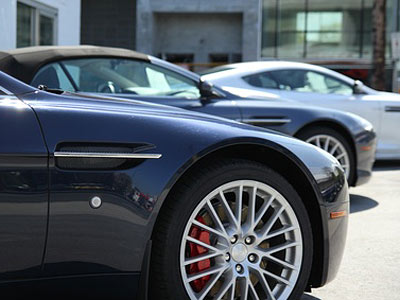 Zwei Sportwagen in der Seitenansicht, einer in Dunkelblau und einer in Silber.