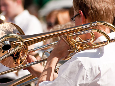 Ein Musiker spielt Posaune in einem Blasorchester.