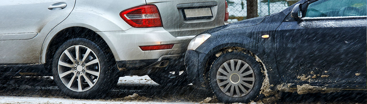 Zwei Autos, eines silber und eines schwarz, sind bei Schnee und schlechter Sicht frontal kollidiert.