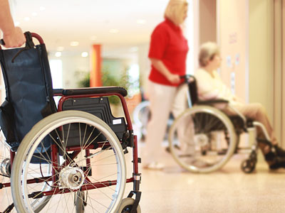Ein Flur mit Rollstühlen und zwei Personen, die sich bewegen.