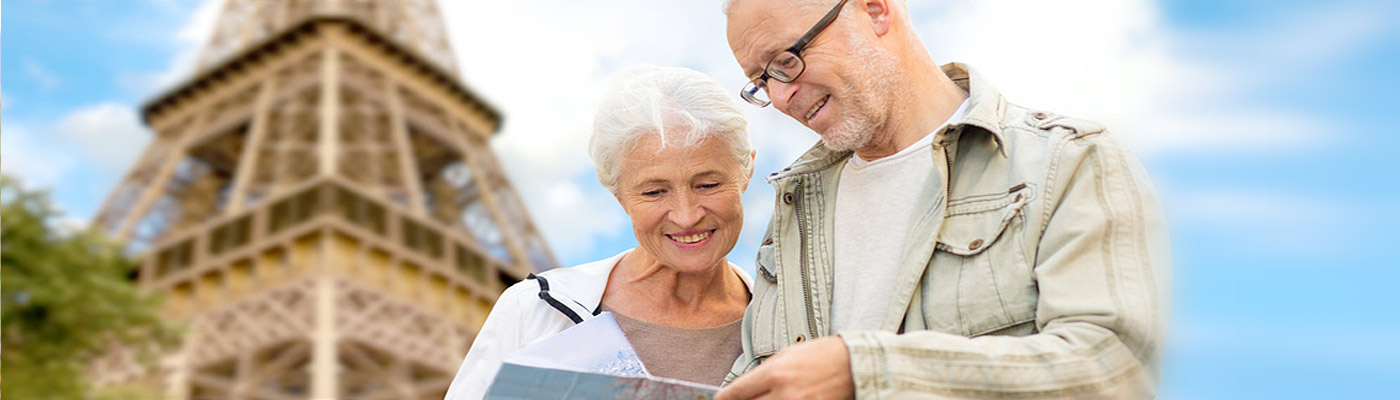 Ein älteres Paar schaut auf eine Karte mit dem Eiffelturm im Hintergrund.