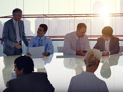 Eine Besprechung in einem modernen Büro mit mehreren Personen, die an einem Tisch sitzen und diskutieren.