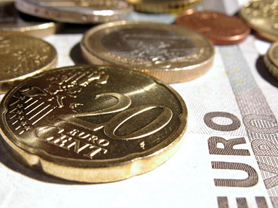 Münzen und Geldscheine, darunter eine 20-Cent-Münze.