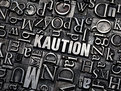 Ein Hintergrund aus Buchstaben mit dem Wort "KAUTION" in der Mitte.