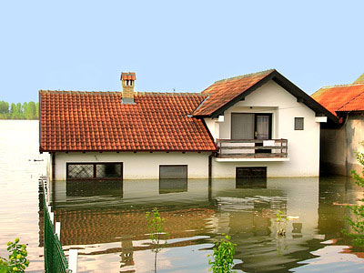 Ein Haus, das teilweise überflutet ist, mit Wasser, das bis zu den Fenstern reicht.