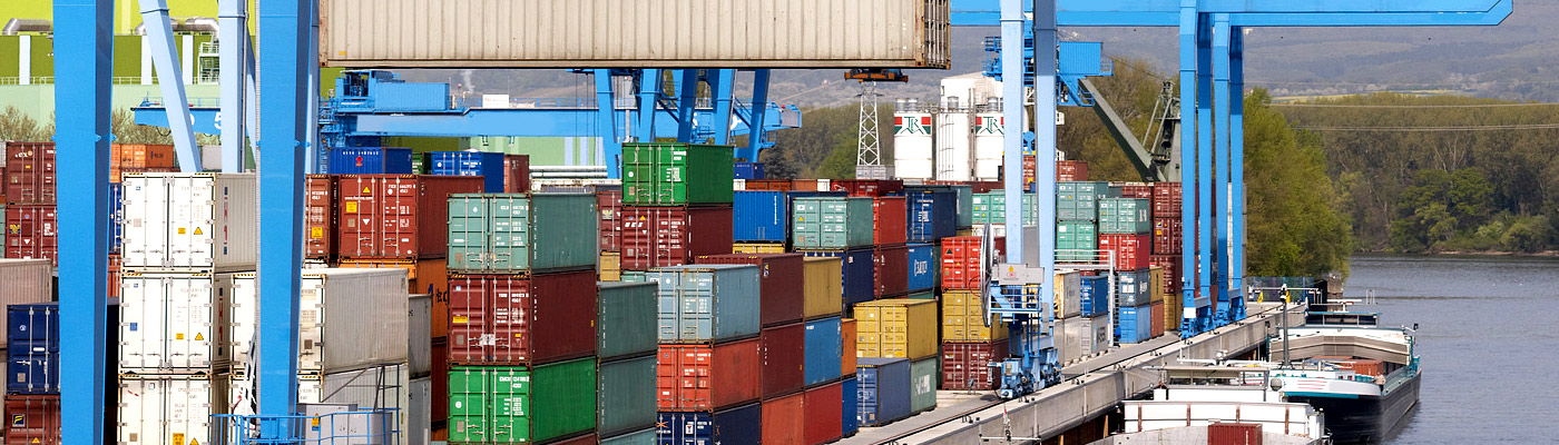 Ein Hafen mit Containern und Kränen, die Container verladen.