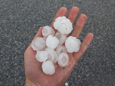 Eine Hand hält mehrere Hagelkörner.