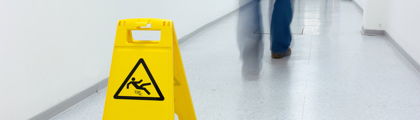 Warnschild vor Rutschgefahr in einem Flur.