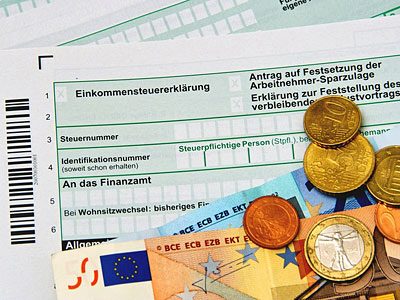 Ein Einkommensteuererklärungsformular mit Münzen und Banknoten.
