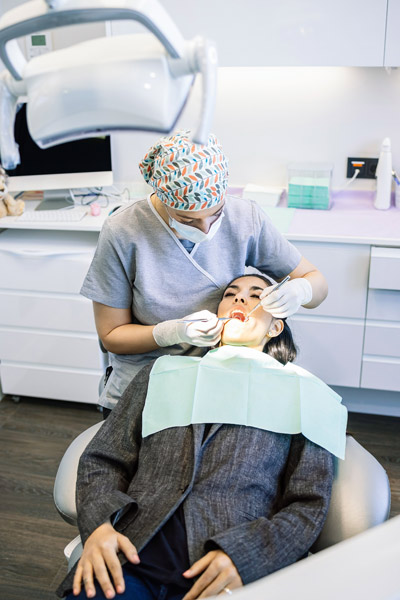 Eine Zahnärztin behandelt einen Patienten in einer Zahnarztpraxis.