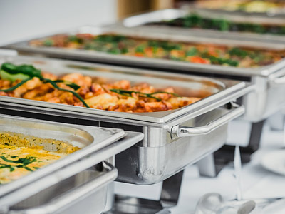 Ein Buffet mit mehreren Chafing-Dishes, gefüllt mit verschiedenen Gerichten.