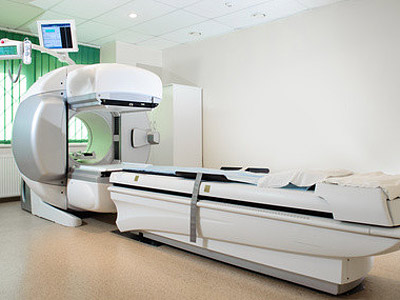 Ein CT-Scanner im Untersuchungsraum mit einer Liege.