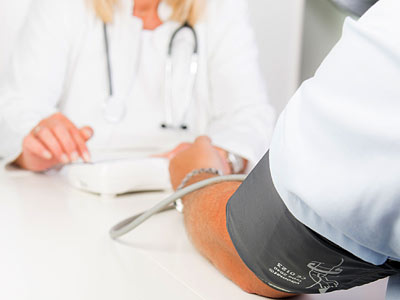 Eine Ärztin misst den Blutdruck eines Patienten.